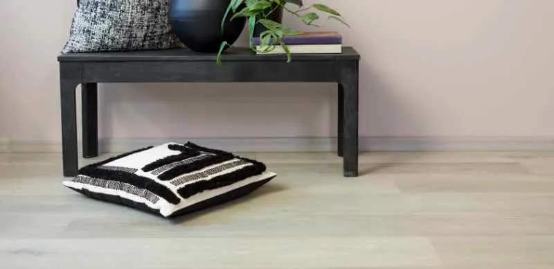 Konsollbord mot hvit vegg med vinylgulv